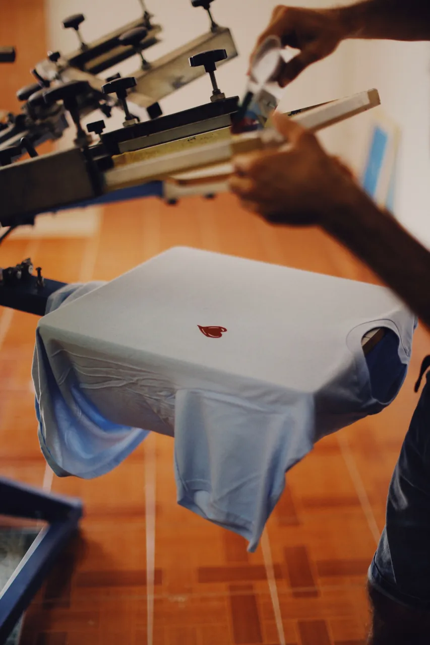 Foto ilustrasi proses sablon kaus dengan alat cetak manual